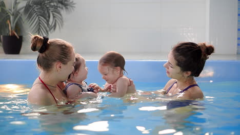 group of mums with their baby children at infant swimming class