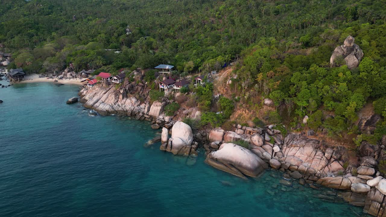Slow tilt up reveal over beautiful cliffs and tropical island - drone view