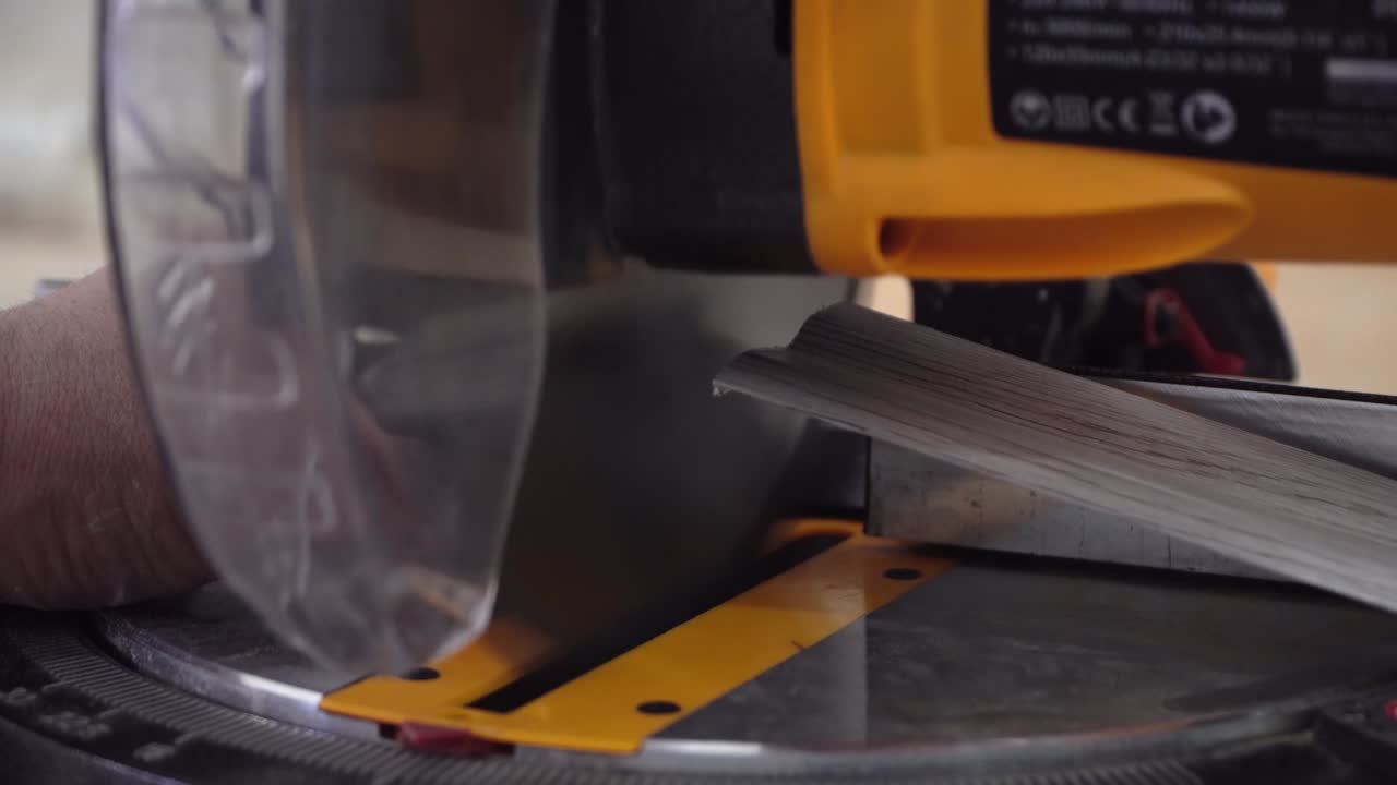 человек, разрезающий ламинатный пол с помощью электрической круговой пилы