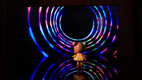 little girl stands in front of a rotating multicolored funnel