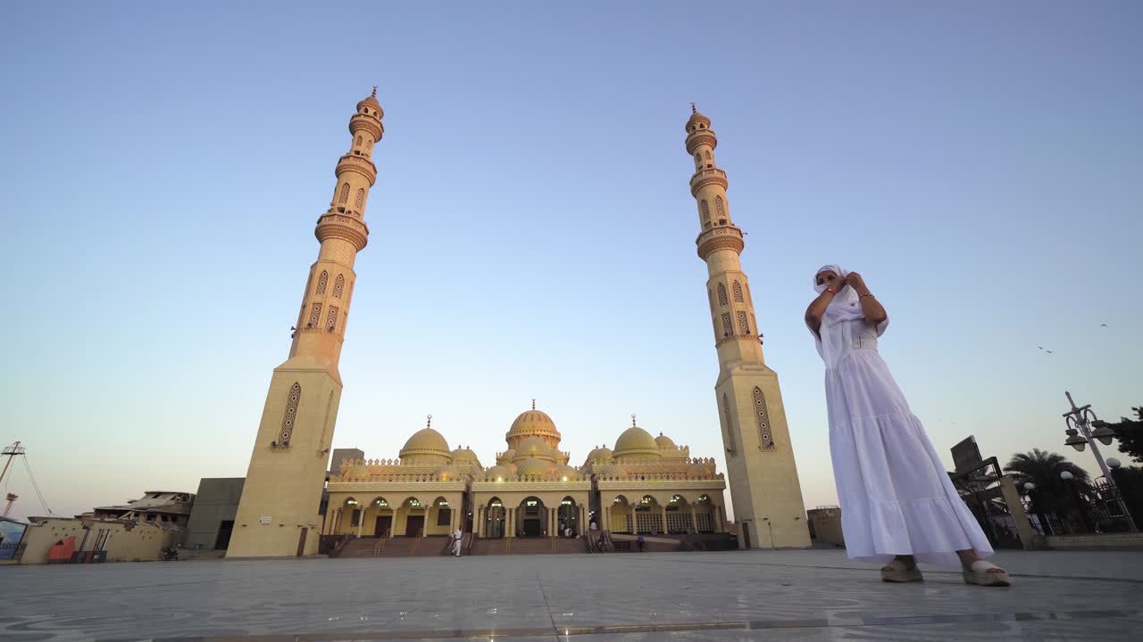 mujer turista visitando la mezquita de el mina en el tradicional hijab y un largo vestido blanco en hurghada, egipto