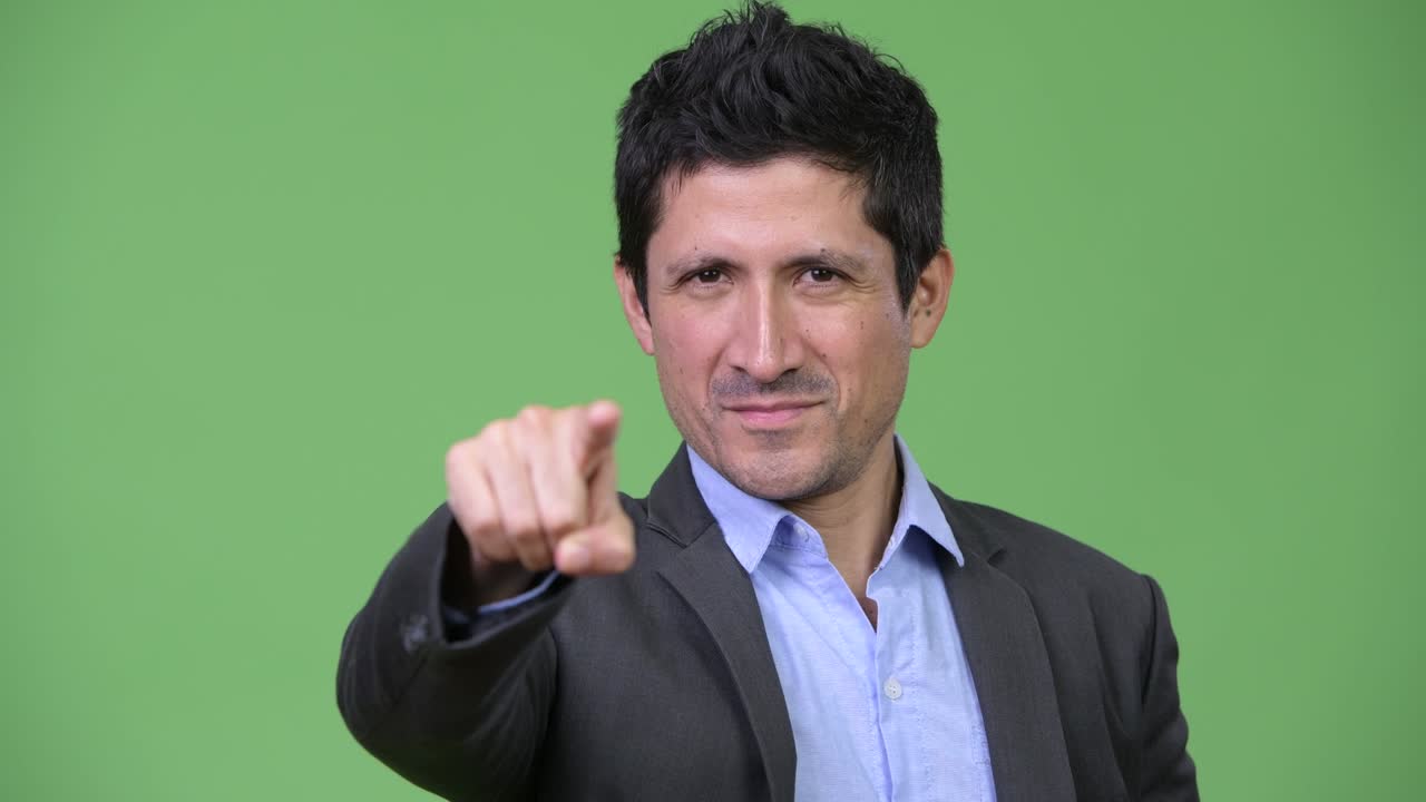 Happy Hispanic businessman pointing to camera