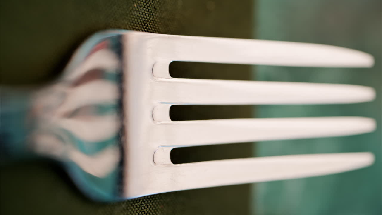 Close up of a fork on a green napkin. Vertical