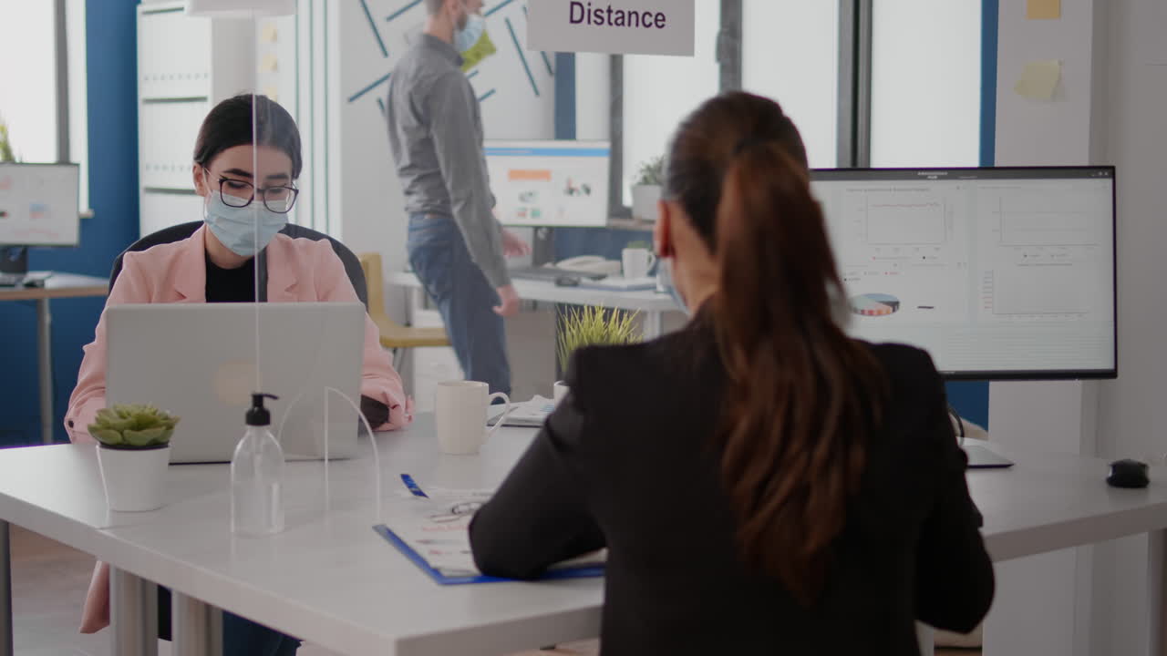 프리랜서가 새로운 정상적인 사무실에 앉아서 동료와 사업 시작에 대해 이야기하고 있습니다.