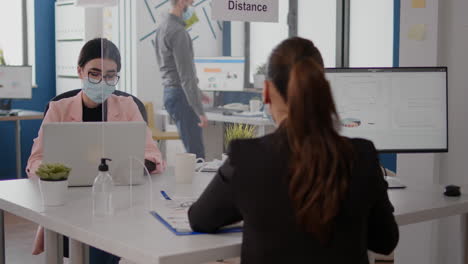 freelancer hablando con un compañero de trabajo sobre la estrategia de negocios mientras está sentado en una nueva oficina normal