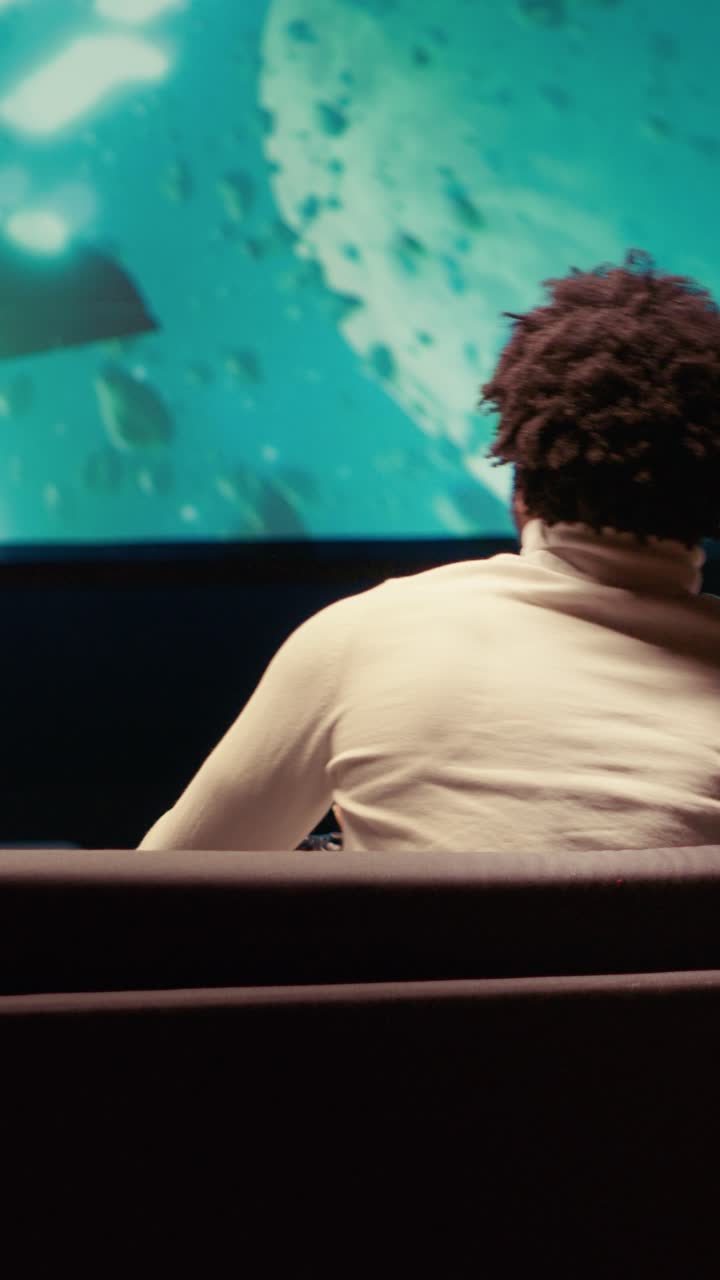 Vertical video Gamer enjoying high quality ray tracing graphics in console videogame on TV