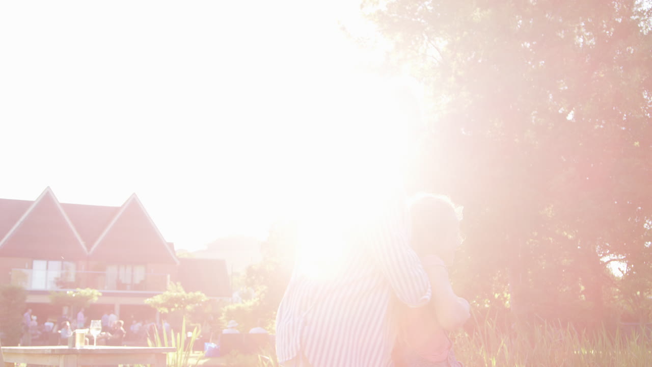 할머니는 여름 술집의 정원에서 게임을 하고 손녀를 흔들고 있습니다.