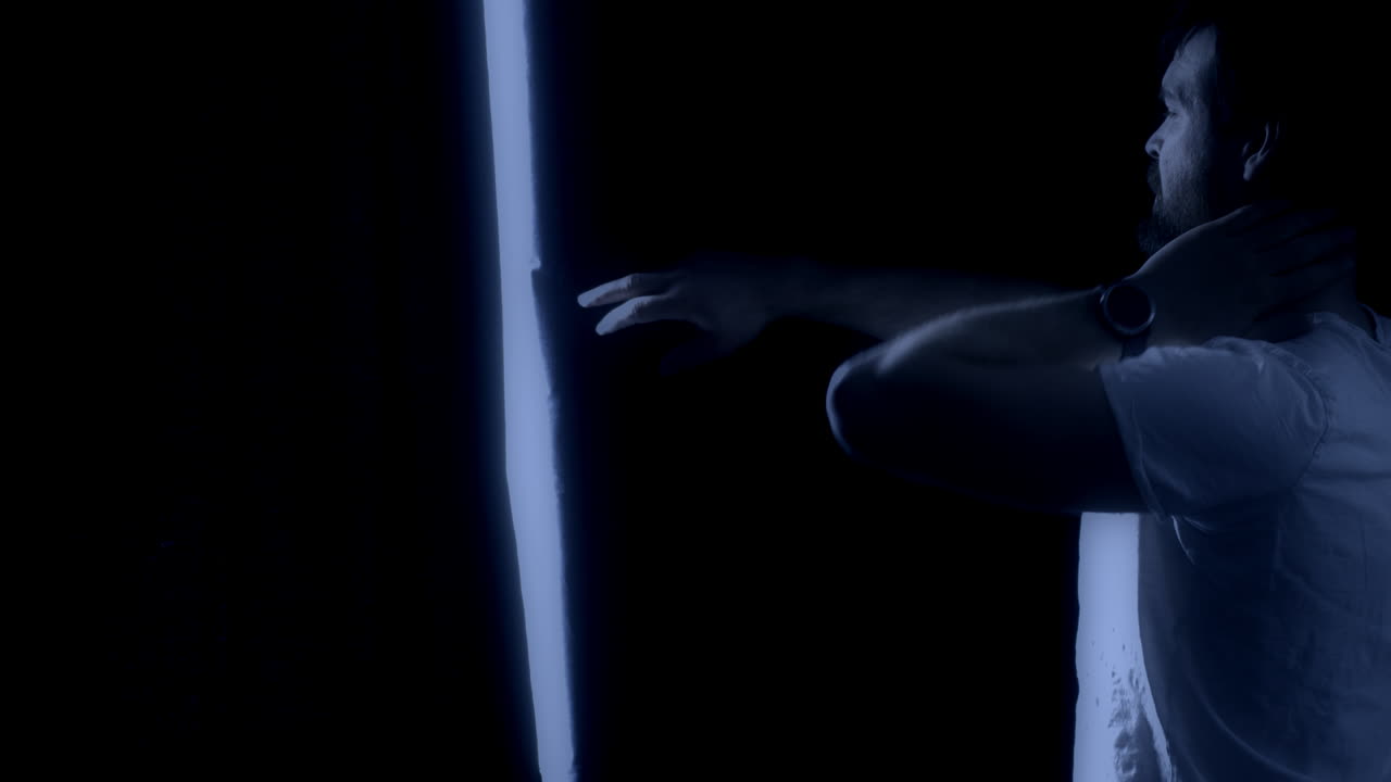 잠 못 이루는 수염 난 남자가 밤에 커튼을 열고 슬로우 모션