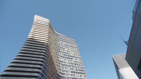 modern curved skyscraper against a clear blue sky