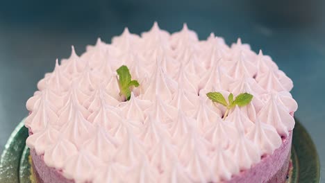 woman puts mint leaves to decorate pink biscuit cake