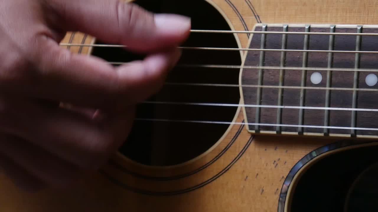 primer plano de la mano del hombre tocando la guitarra