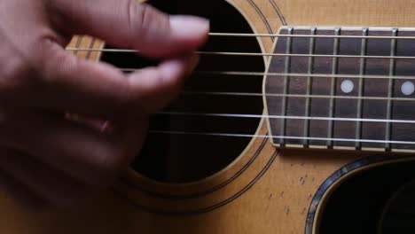 close up shot of man's hand playing guitar