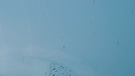 windshield wipers wiping off raindrops to avoid blurring view - close up