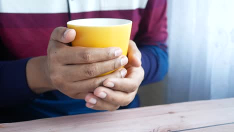 person holding a yellow mug