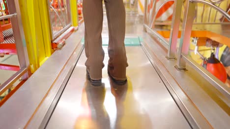 person walking on a moving walkway in an amusement park