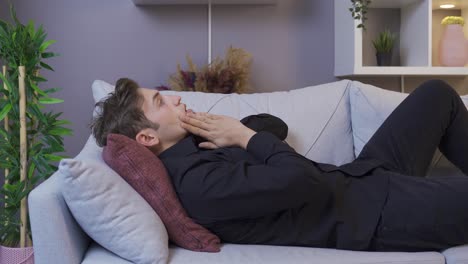Frustrated young man sitting on the sofa.