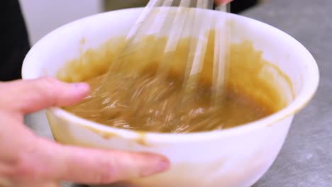 chef de pastelería batiendo salsa de caramelo en un cuenco para el postre