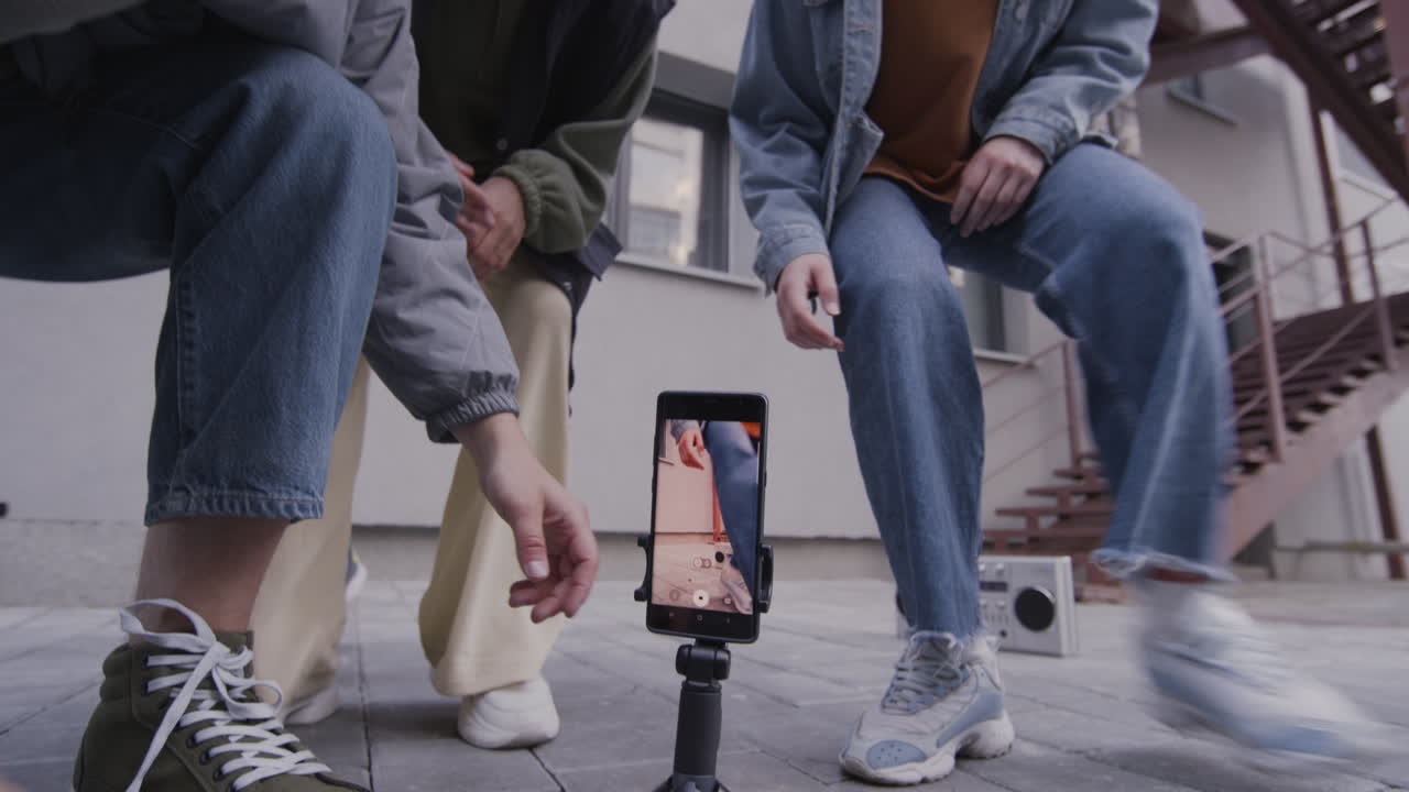 молодые люди танцуют на улице.