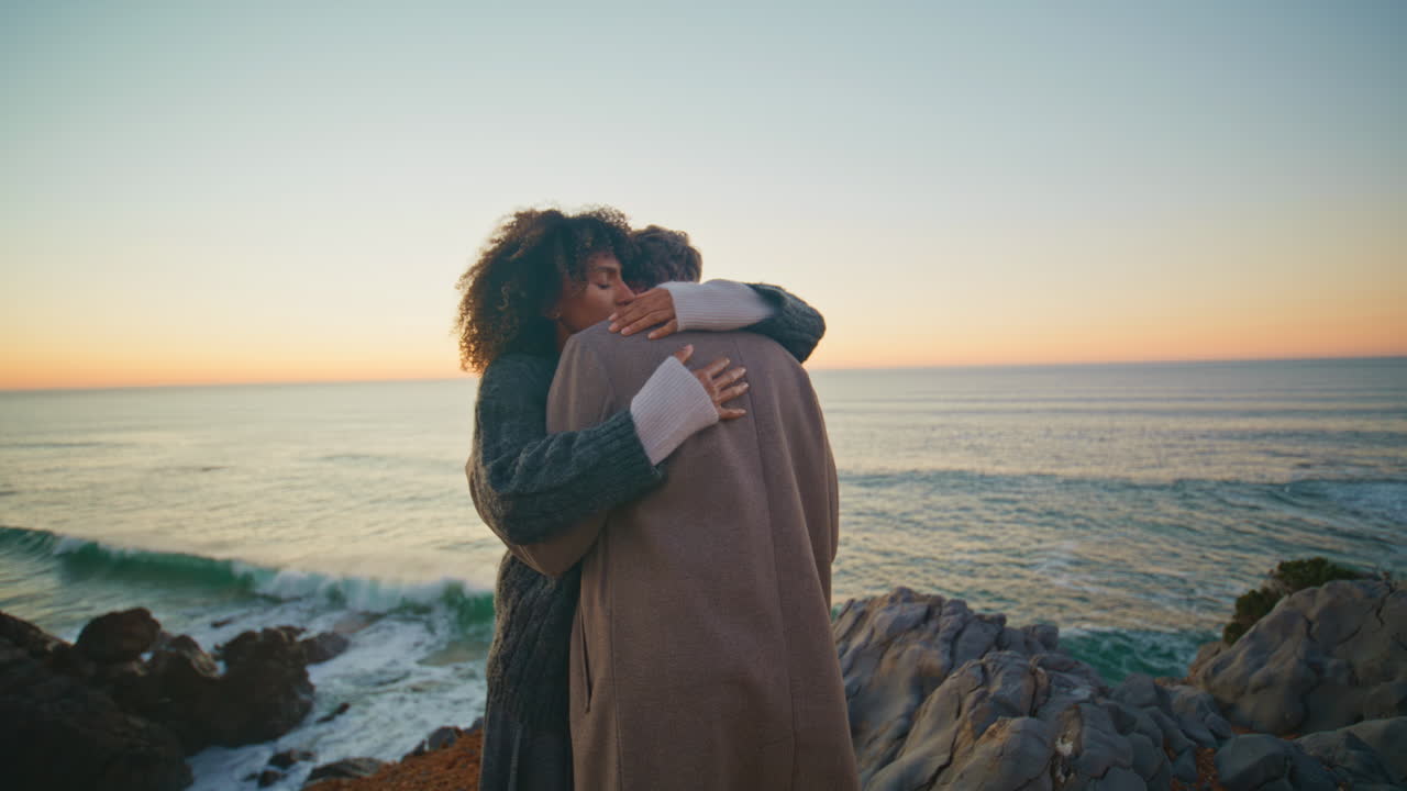 Romantic lovers dating ocean evening beach. Gentle man embracing woman at sunset