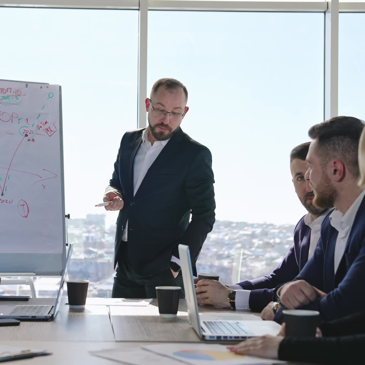 Empresario mostrando y explicando el gráfico a su lado. Colegas en una presentación con rotafolio en un seminario. Socios comerciales hacen sugerencias en la reunión.