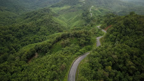 aerial view flying above lush green tropical rain forest mountain with rain cloud cover during the rainy season on the doi phuka mountain reserved national park the northern thailand