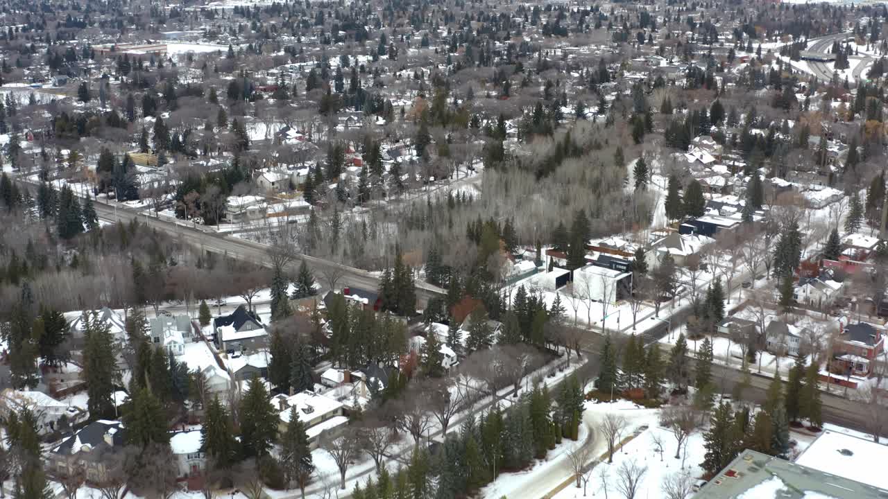 vista aérea de invierno a vista de pájaro vuela sobre el antiguo museo real de alberta designado por su majestad la reina isabel ii alrededor de la comunidad residencial de lujo de glenora con caminos cubiertos de nieve árboles altos