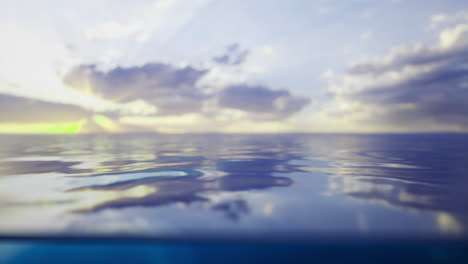 calm ocean water reflects a vibrant sunset under soft clouds