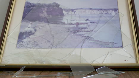 pintura de vidrio rota rota tirada en el suelo después de caerse de la pared