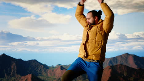 happy climber cheering and feeling pleased while he stretches arms