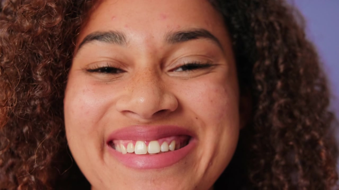 Close-up Portrait of a Smiling Young Woman with Curly Hair