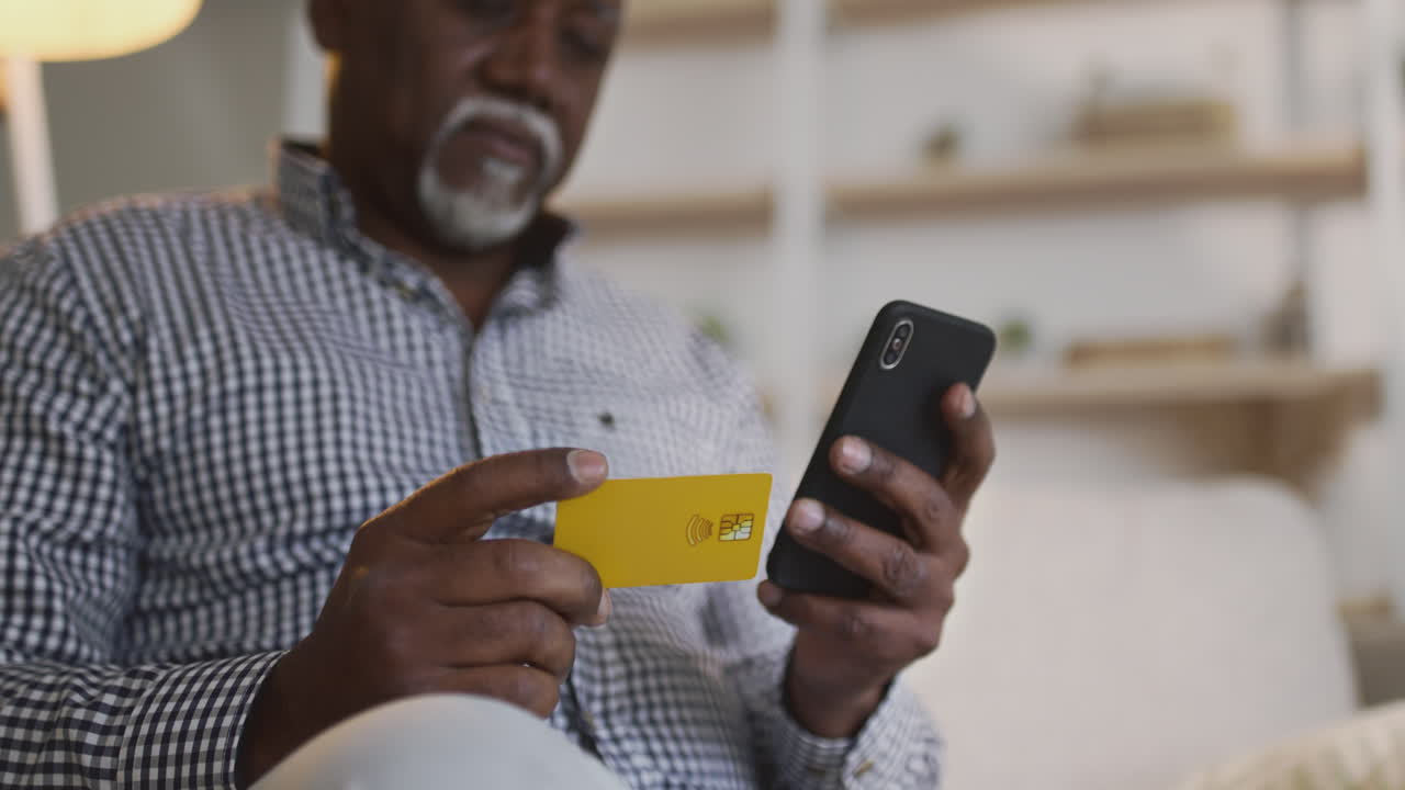 Senior Man Using Smartphone and Credit Card for Mobile Payment