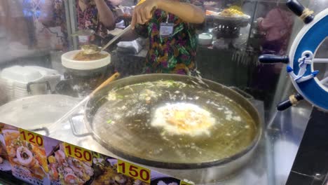 street food vendor preparing seafood omelette