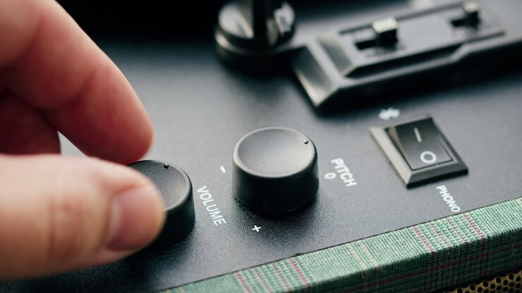 Primo piano di una mano che regola i controlli del giradischi