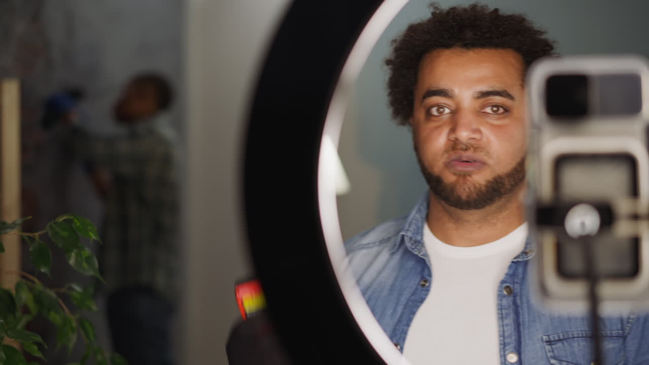 Uomo di colore registra un tutorial sulla ristrutturazione con un amico.
