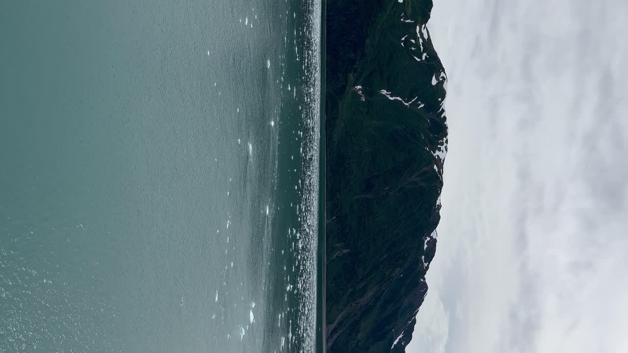 hielo flotando cerca de la costa por el glaciar hubbard, alaska - orientación vertical