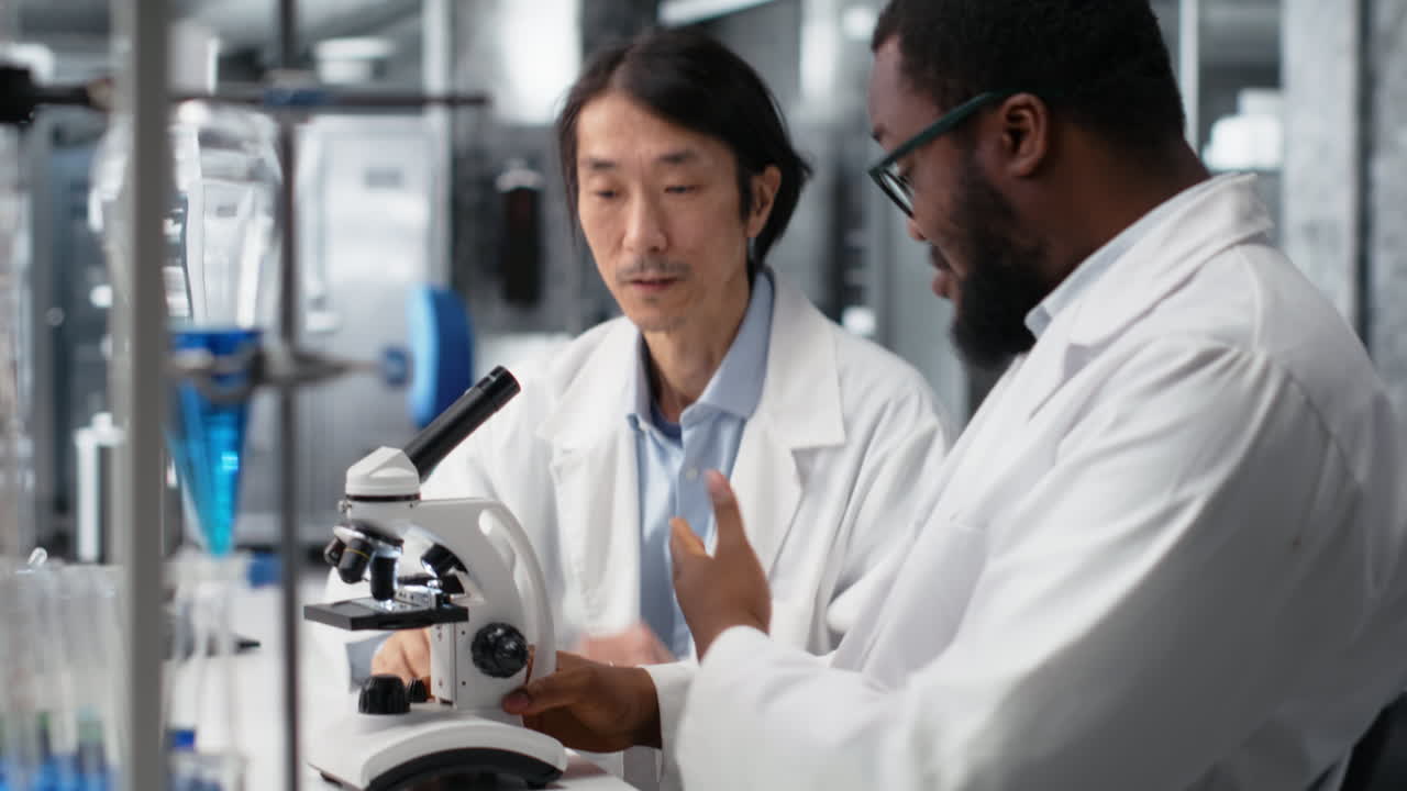 Vertical video Team of multiethnic researchers using microscope