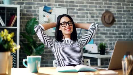 cinemagraph portrait of happy young woman relaxing in offce with cup of coffee