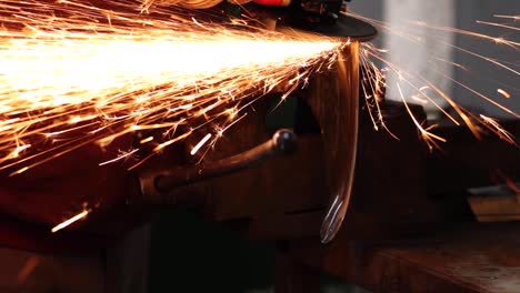 Craftsman-grinding-metal-with-grinder-in-vice