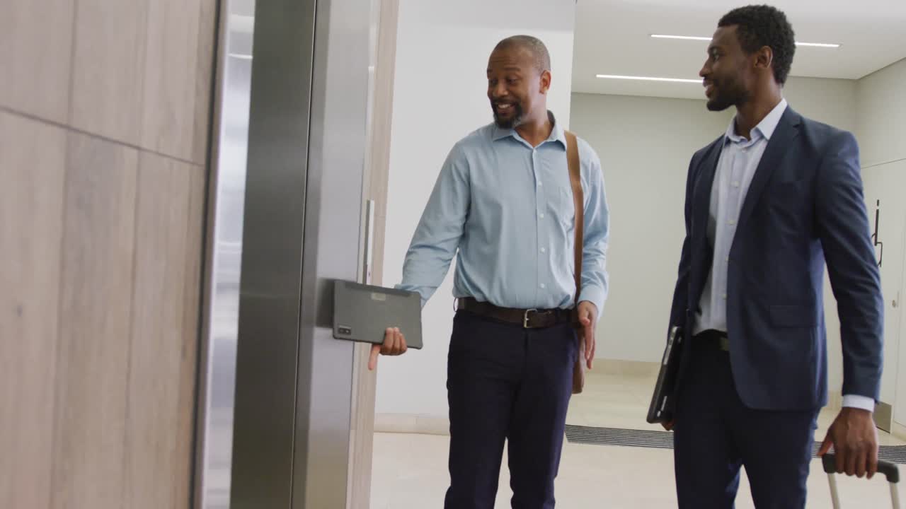 Happy diverse business people taking elevator at office, slow motion