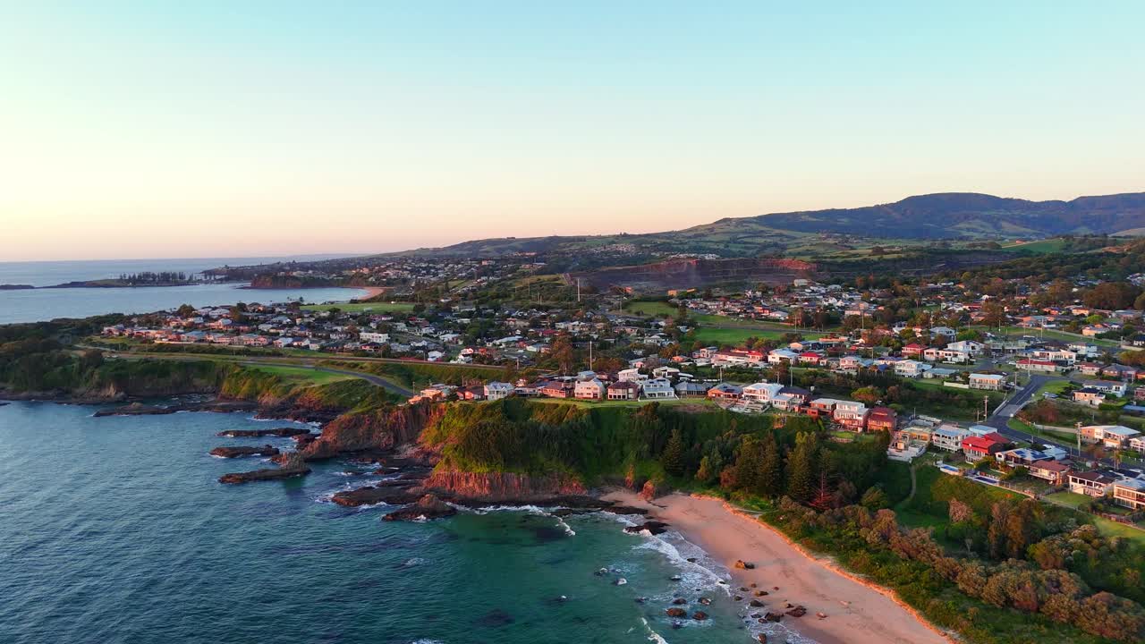 Aerial establishing of Jones Beach in Kiama Downs with cliffs and ocean waves along coastline