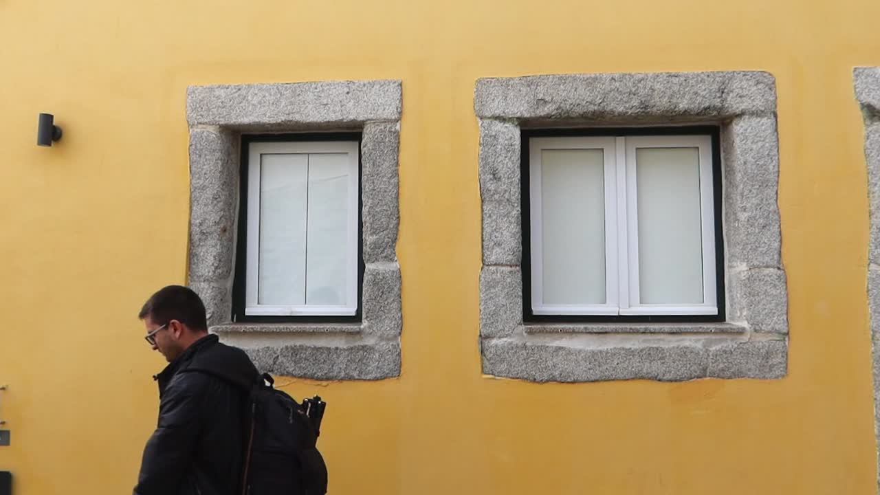 viajero solitario con mochila y gafas camina por las calles de oporto, portugal