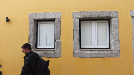 solo traveler with backpack and glasses walks in streets of porto, portugal