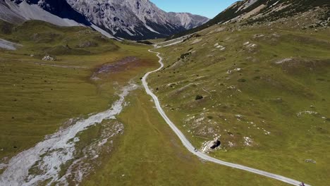 following bikers in a high mountain valley road with rocky summits on the background