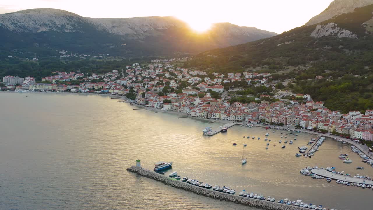 la hermosa y tranquila ciudad turística de baska cerca del puerto con barcos y yates anclados por el mar en calma durante la hora dorada en la isla de krk, croacia