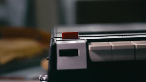 record button pressed on portable retro home media cassette player close-up