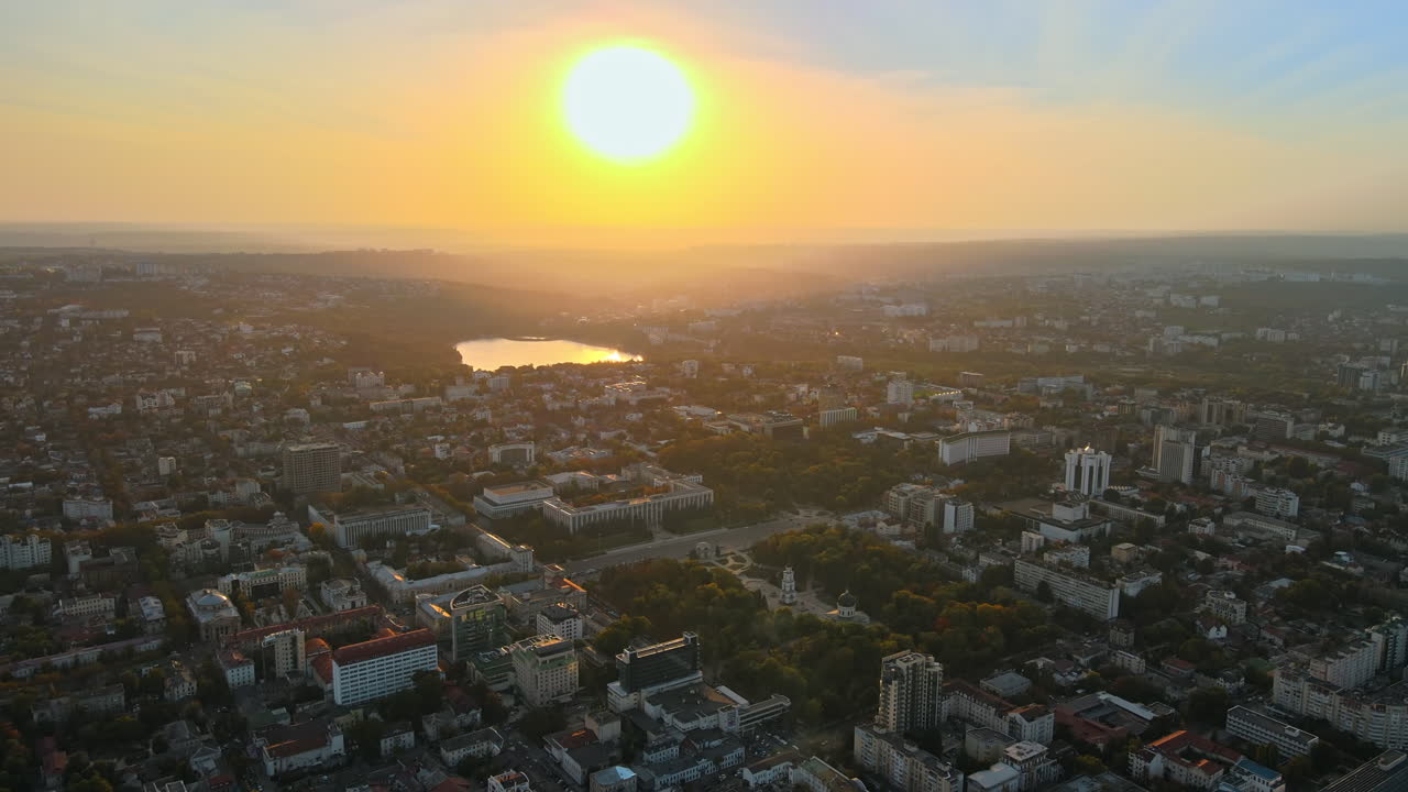 Vista aerea di Chișinău al tramonto con drone. Parco con vegetazione lussureggiante e lago. Vista panoramica di numerosi edifici. Moldova