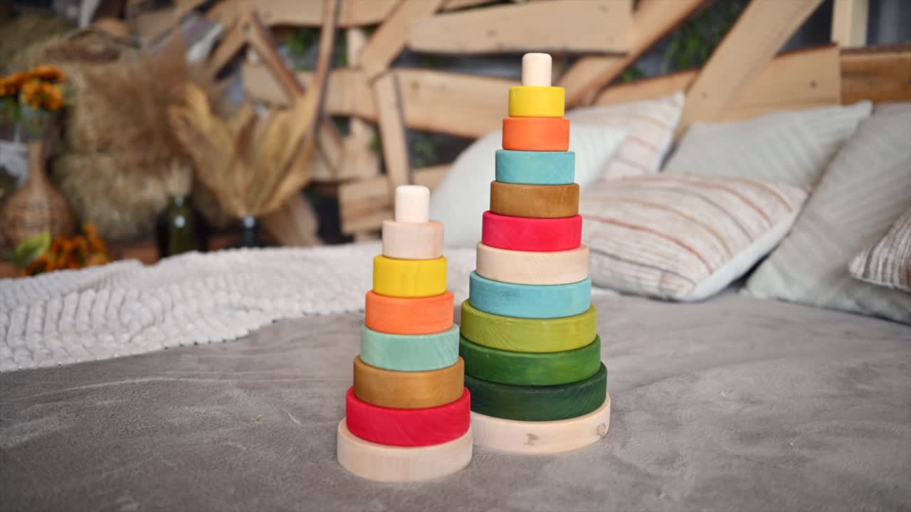 Colourful, ecological wooden toys sitting on bed with rustic decor on the background