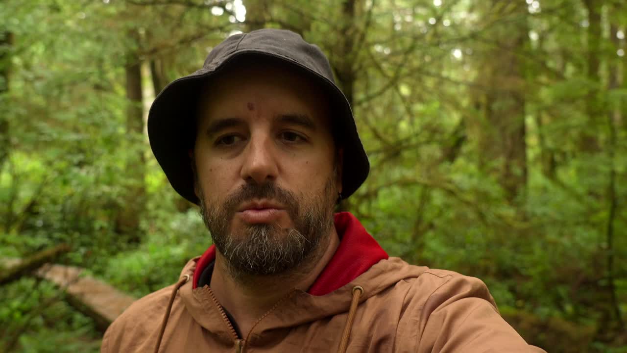 Mand i skoven iført en hoodie og bøllehat