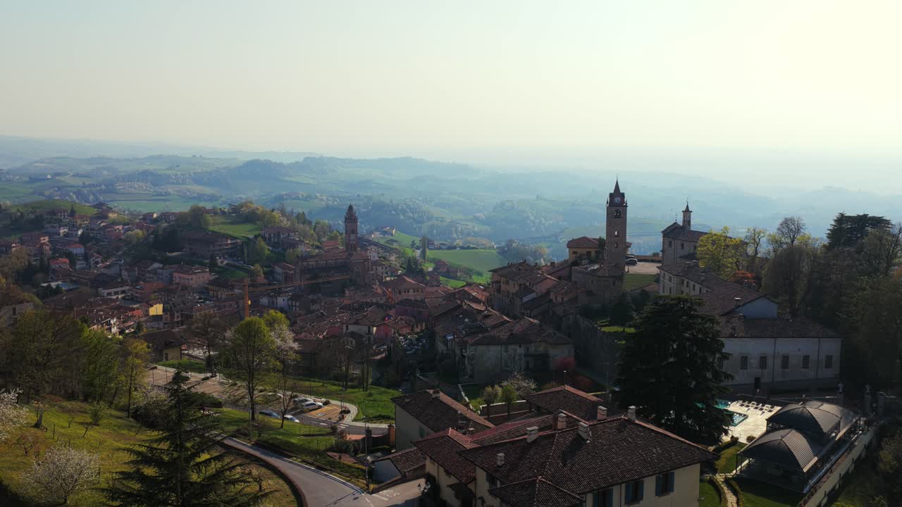 Aerial View Of Monforte d'Alba - Picturesque Italian Village With Historic Towers, Terracotta Rooftops, And Misty Hills In Background. static drone shot