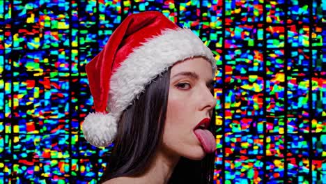 mujer con sombrero de santa con la lengua afuera contra un fondo abstracto